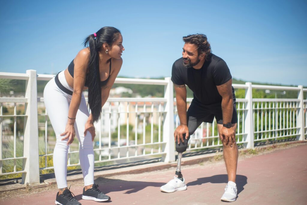 Twee mensen joggen in het park met de professionele begeleiding van Fitlipgym glimlachend en energiek, illustrerend hoe de support van de gym bijdraagt aan een actieve levensstijl