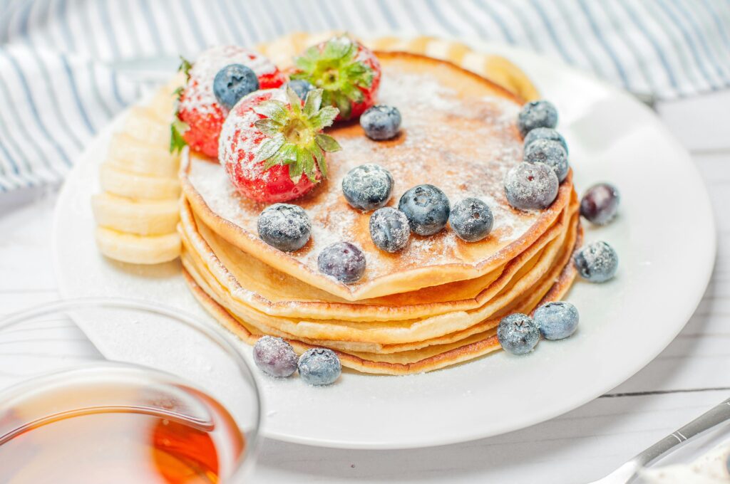 Glutenvrij ontbijt met heerlijke pannenkoeken met fruit zoals bosbessen