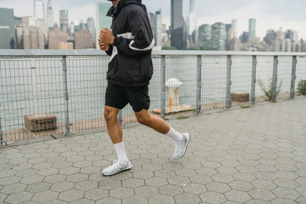 "Man doet een cardio-oefening tijdens een hardloopsessie langs het water, gericht op conditieverbetering en gewichtverlies bij Fitlipgym.